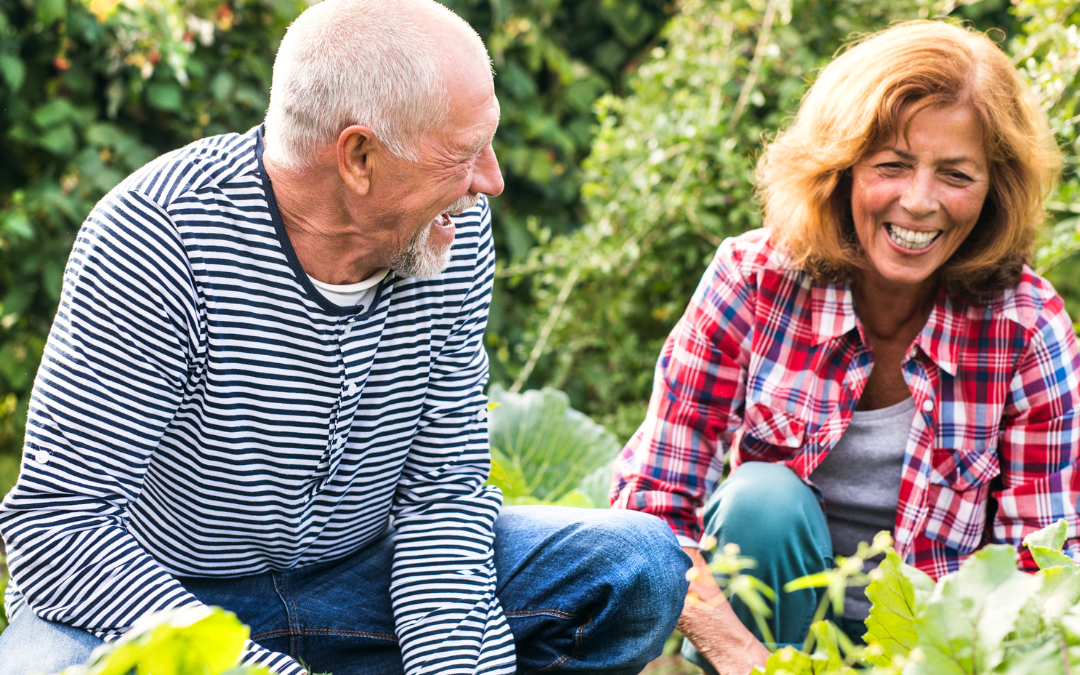 happy seniors kneeling in the garden